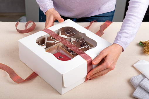 Process of packing confectionery gift box. Cookies in cardboard box.