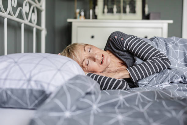 istock Senior woman is sleeping in bed at home 1291490348