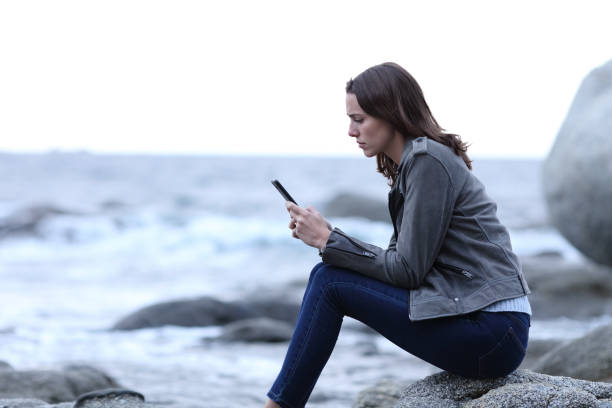 istock Worried woman reading phone message on the beach 1291491121