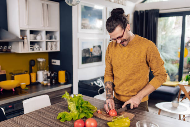 istock Young man making a vegetable meal at home 1291495197