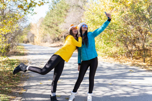 istock Two excited young girls having fun while taking selfie together at the park 1291499921