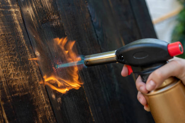 falegname professionista che utilizza la vecchia tecnica tradizionale giapponese. assi di legno in fiamme con bruciatore a gas - gas fitter immagine foto e immagini stock