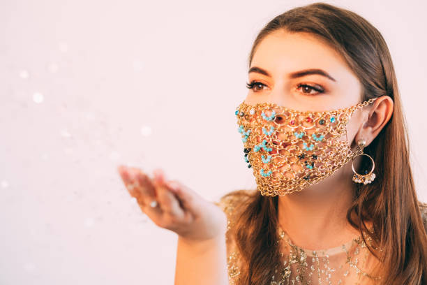 istock christmas magic woman glamour mask bokeh light 1291506635