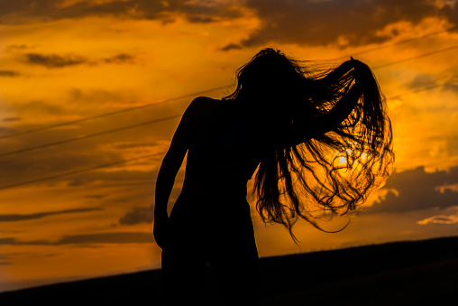 Silhouette of a woman against the backdrop of the sunset