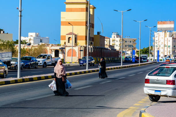 エジプトのダハル地区(ハルガダ市の旧市街)で買い物袋を持って道路を横断するヒジャーブの正体不明のアラビア人イスラム教徒の女性 - beautiful horizontal arabia hurghada ストックフォトと画像