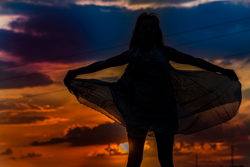 Silhouette of a woman against the backdrop of the sunset