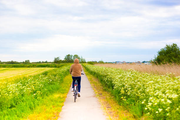istock Young Woman Cyclist on Flowery Path, Springtime (Netherlands) 1291516644