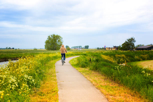 istock Young Woman Cyclist near Canal, Springtime (Netherlands) 1291517270