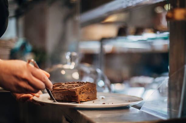 istock Female confectioner taking a slice of cake 1291518154