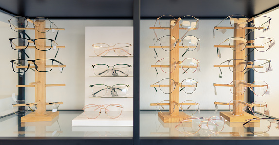 eyeglasses display on glasses stand on shelves in optical store.