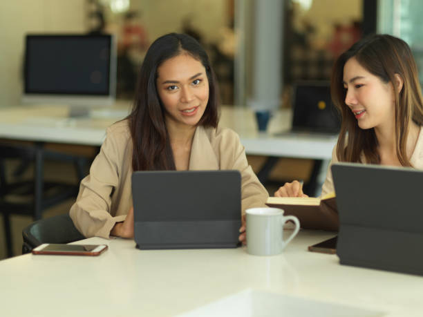 istock Two female office workers brainstorming on their work with digital tablets in meeting room 1291521092