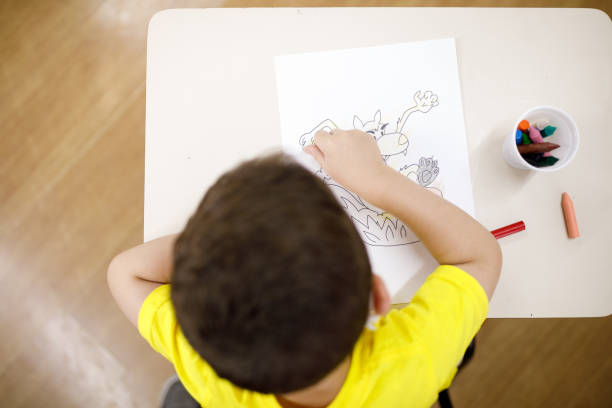 istock high angle view of a little boy painting a drawing using crayons 1291523529