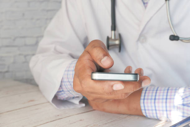 istock doctor in white coat using a smartphone. 1291526104