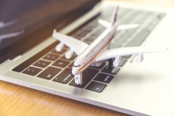 istock laptop computer and airplane on table. Online ticket booking concept 1291528473
