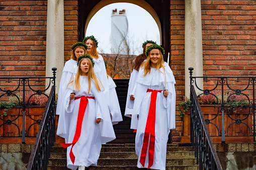 Stockholm, Sweden Dec 9, 2020 A school group in Liljeholmen performs a traditional  Santa Lucia celebration with song on the steps of school.