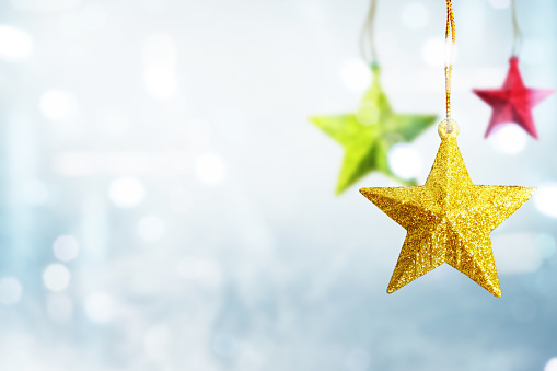 Colorful Christmas star hanging with blurred light background. Merry Christmas