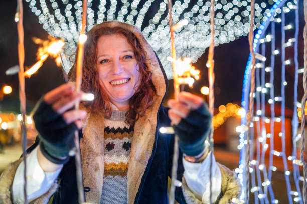 istock Cheerful young woman having fun with Christmas light 1291540366
