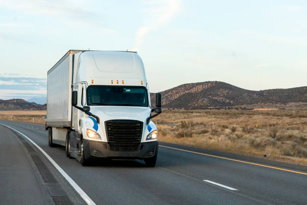istock Long Haul Semi Trucks on A Two Way Highway 1291541649