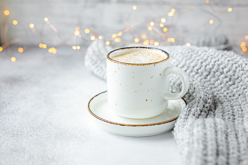 Cup of coffee, scarf and garland. Cozy autumn or winter composition. Scandinavian style - Image