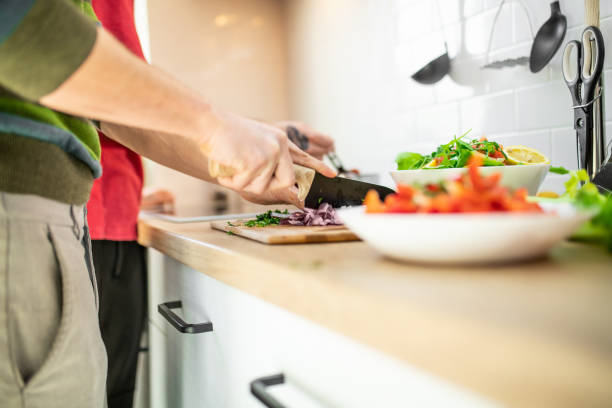 istock Two men chopping vegetables for salad and making lunch together 1291543629