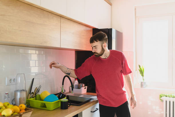 istock Young man in the kitchen picking the utensil for preparing breakfast 1291545739