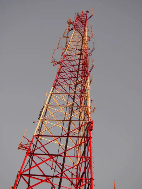 Red and White Communication tower at dusk against a foggy sky in California.