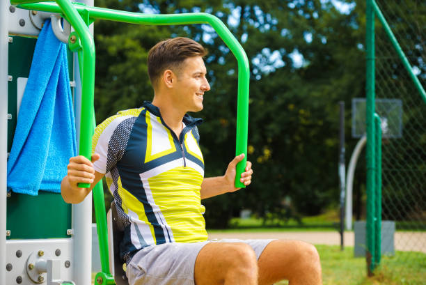 istock Man flexing arm in outdoor gym 1291545868