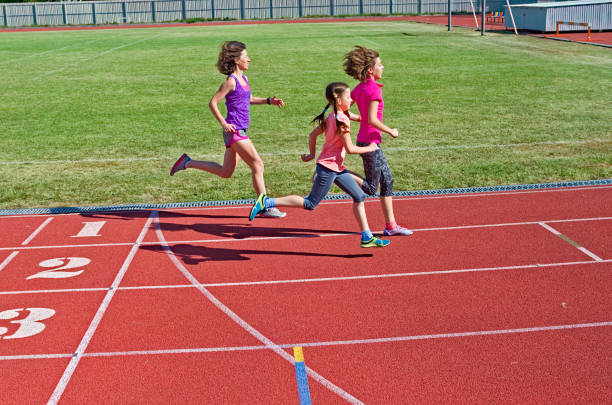 fitness familial, mère et enfants exécutant sur la piste de stade, l’entraînement et les enfants sport concept de mode de vie sain - track and field 30s adult athlete photos et images de collection