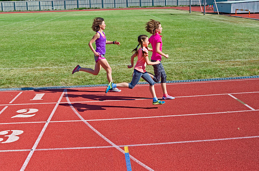 Family fitness, mother and kids running on stadium track, training and children sport healthy lifestyle concept