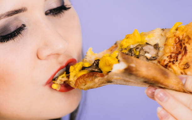istock Woman eating hot pizza slice 1291546909
