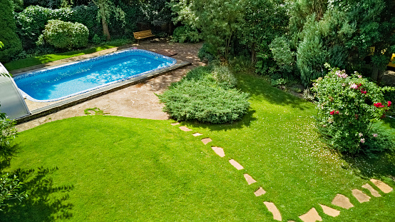 Swimming pool in beautiful garden aerial top view