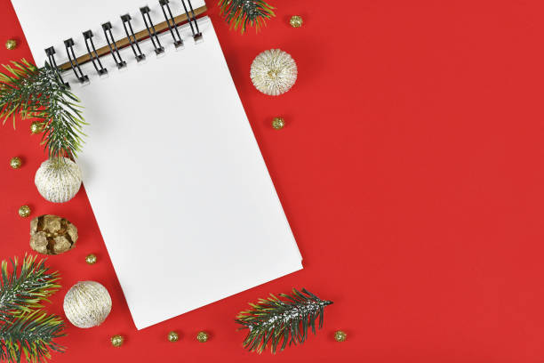 istock White empty notebook surrounded by Christmas decoration in corner of red background 1291550023