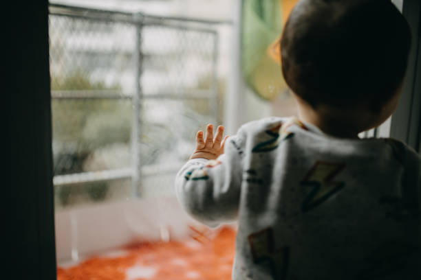 istock Rear View Of Boy Standing By Glass Window 1291552660