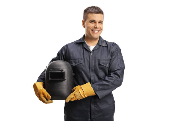 soldador joven y alegre con un uniforme sosteniendo un casco protector - manual worker portrait helmet technology fotografías e imágenes de stock