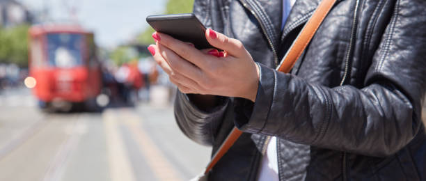 istock Woman using cellphone on a tram station in Europe. 1291555447