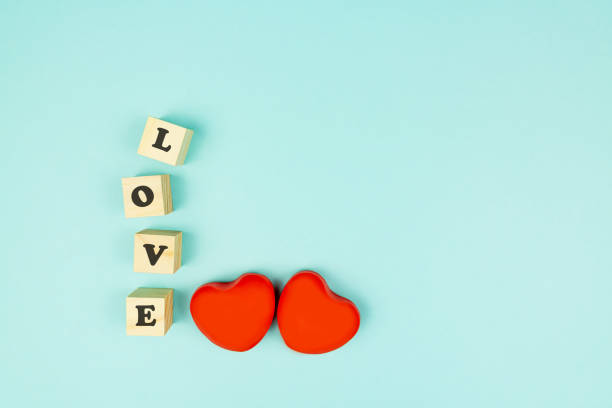 istock Red heart and wooden cubes with text LOVE on blue background. Creative flat lay with copy space. Festive greeting card for St Valentines day. 1291556437
