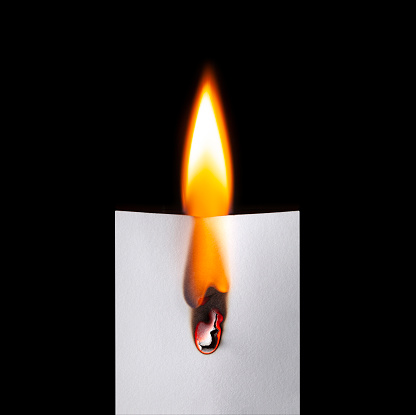 Burning blank sheet of white paper bright with fire flame on black background.