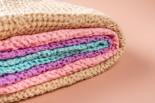 istock Multicolored bath and spa towels twisted into a roll on pink background 1291559924