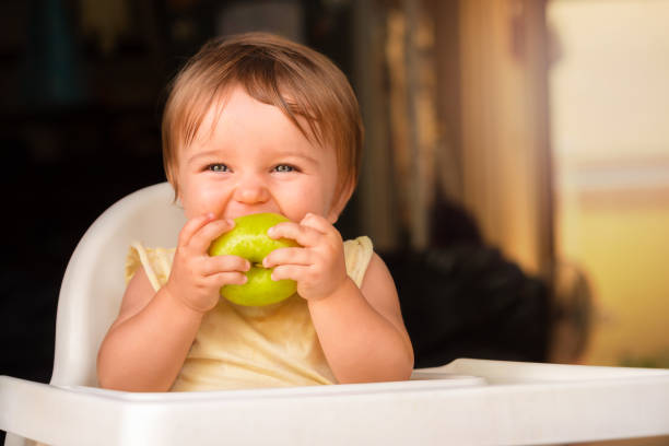 istock baby with green apple 1291560002