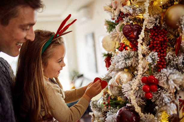 istock Father And Daughter Decorating Christmas Tree 1291560644