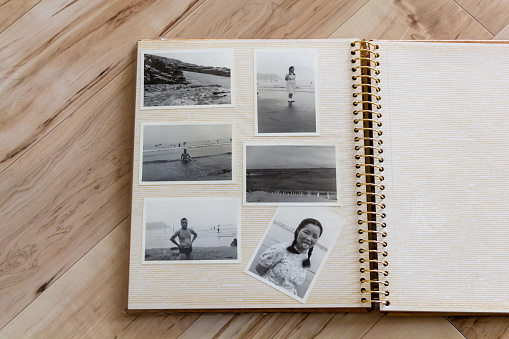 Photo album, old black-and-white photograph of Japanese couple shot in around 60's. Wooden background.