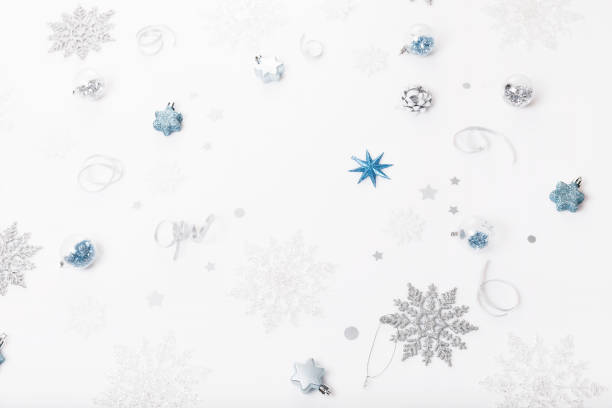 istock Christmas holiday composition. Festive creative silver blue pattern, xmas decor holiday ball with ribbon, snowflakes on white background. 1291567763