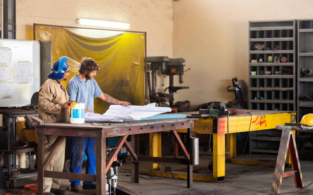 istock Discussing new plans for construction in the metalshop 1291568086