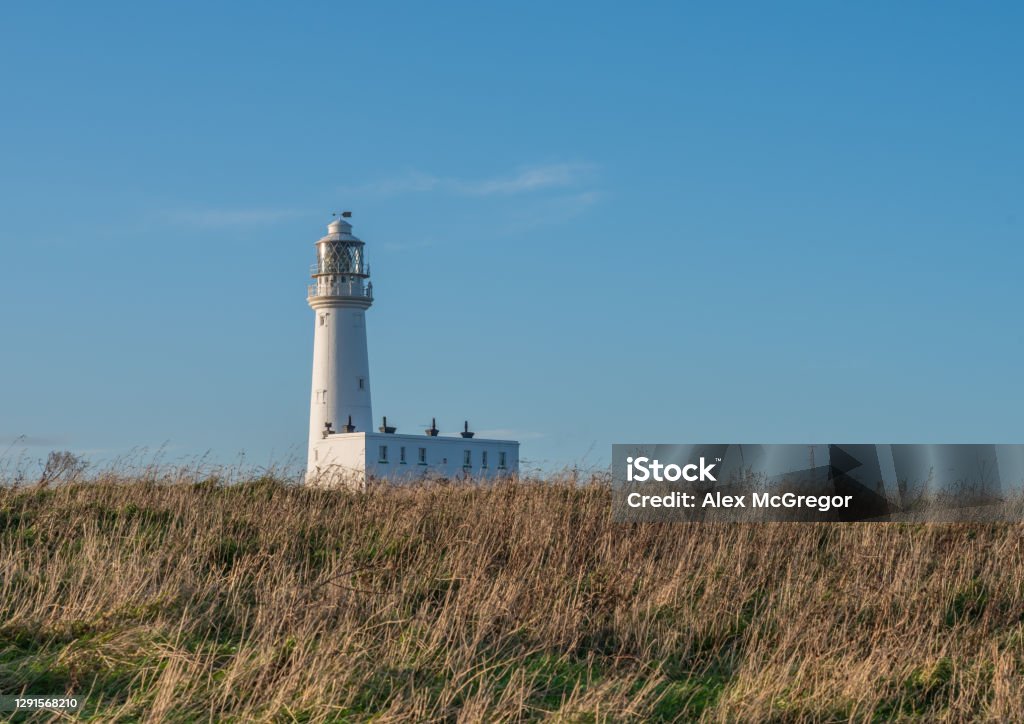 View of traditional lighthouse The Lighthouse at Flamborough Head a white building on a sunny day with blue sky background Architecture Stock Photo
