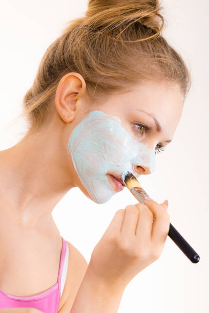 istock Girl apply green mud mask to face 1291570362