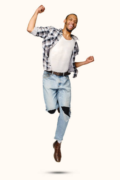 istock Casual african-american man jumping in studio over white background 1291570454