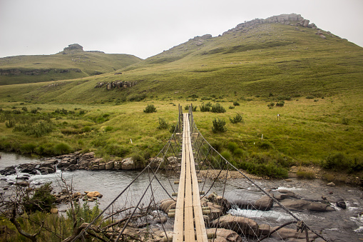 Narrow rope suspension bridge crossing the Pholela River at Cobham camping site in the southern Drakensberg, South Africa