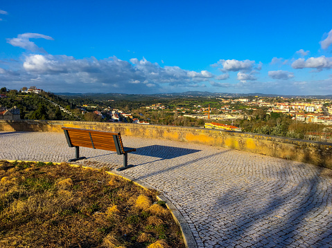 Empty bench and a view on an old Portuguese city at sunset. Blue sky. Copy space. High quality photo