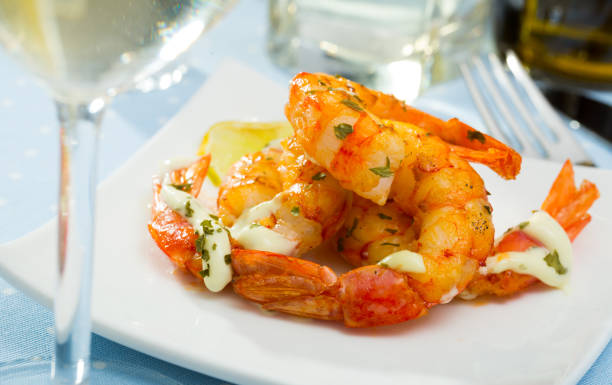 istock Split fried prawns with lemon and parsley on a white plate 1291572672