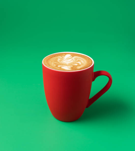 istock Cup of milk coffee on green background, vertical. 1291572960